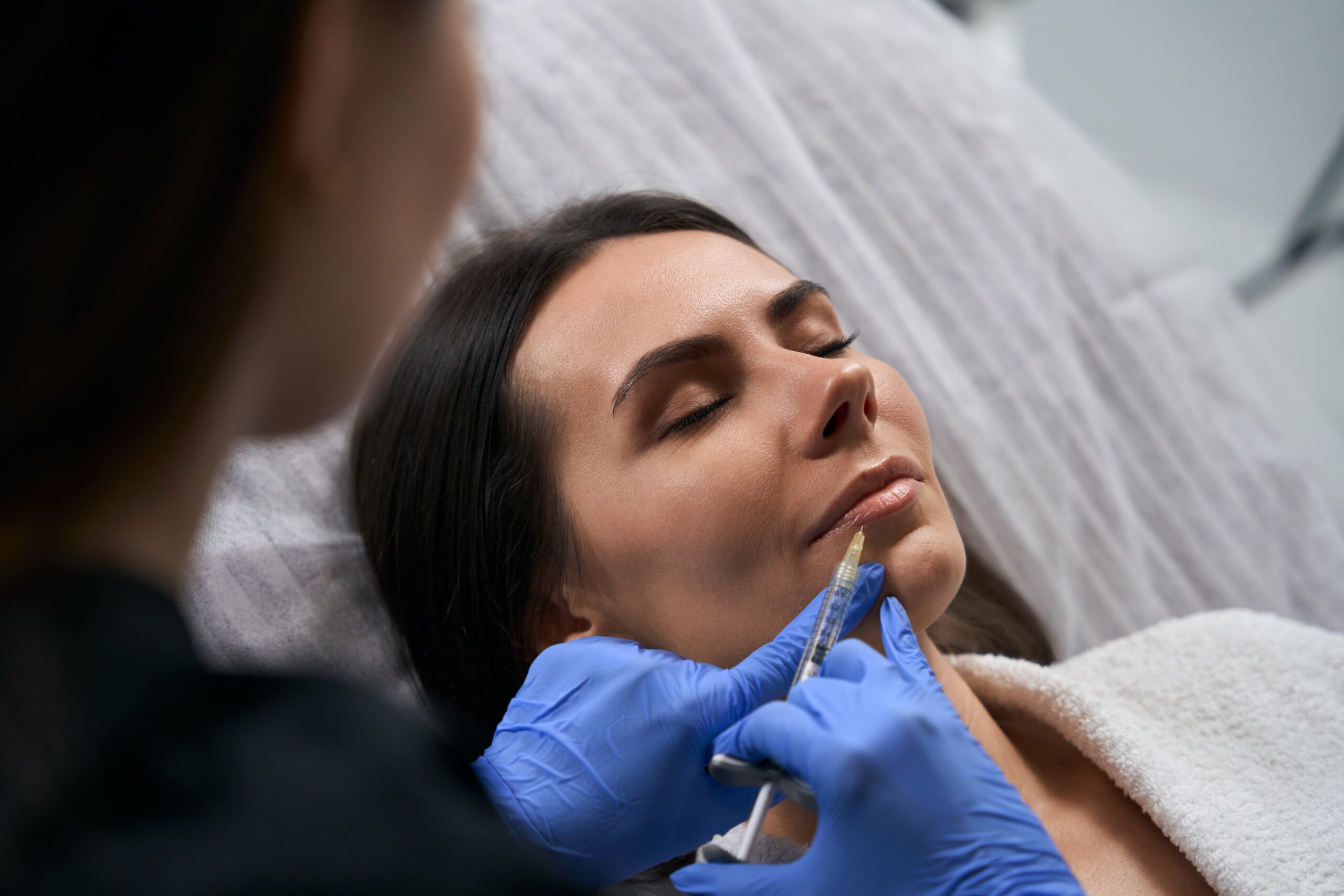 Mulher em atendimento estético na Clínica Saffine, com aplicação de botox para suavizar rugas e preenchimento com ácido hialurônico para restaurar volume facial.